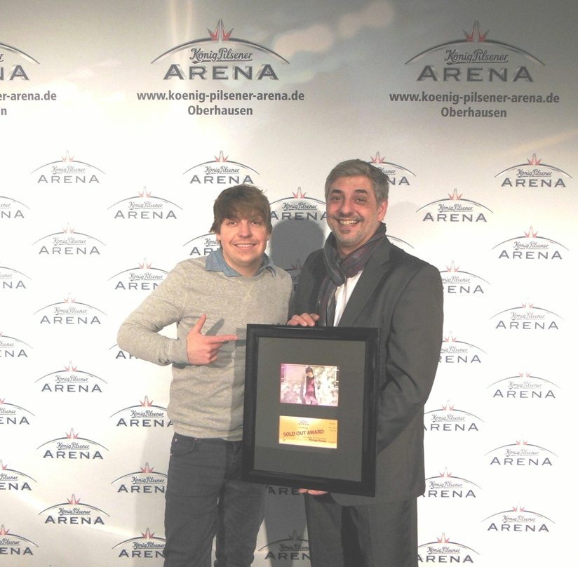 Strahlte bei der Übergabe des Sold Out Awards (von links): Philipp Poisel mit Arena-Geschäftsleiter Johannes Partow