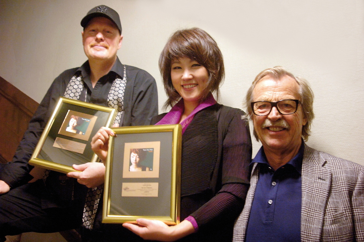 Bei der UBergabe des Awards: Gitarrist Ulf Wakenius, Youn Sun Nah und Siggi Loch (ACT)
