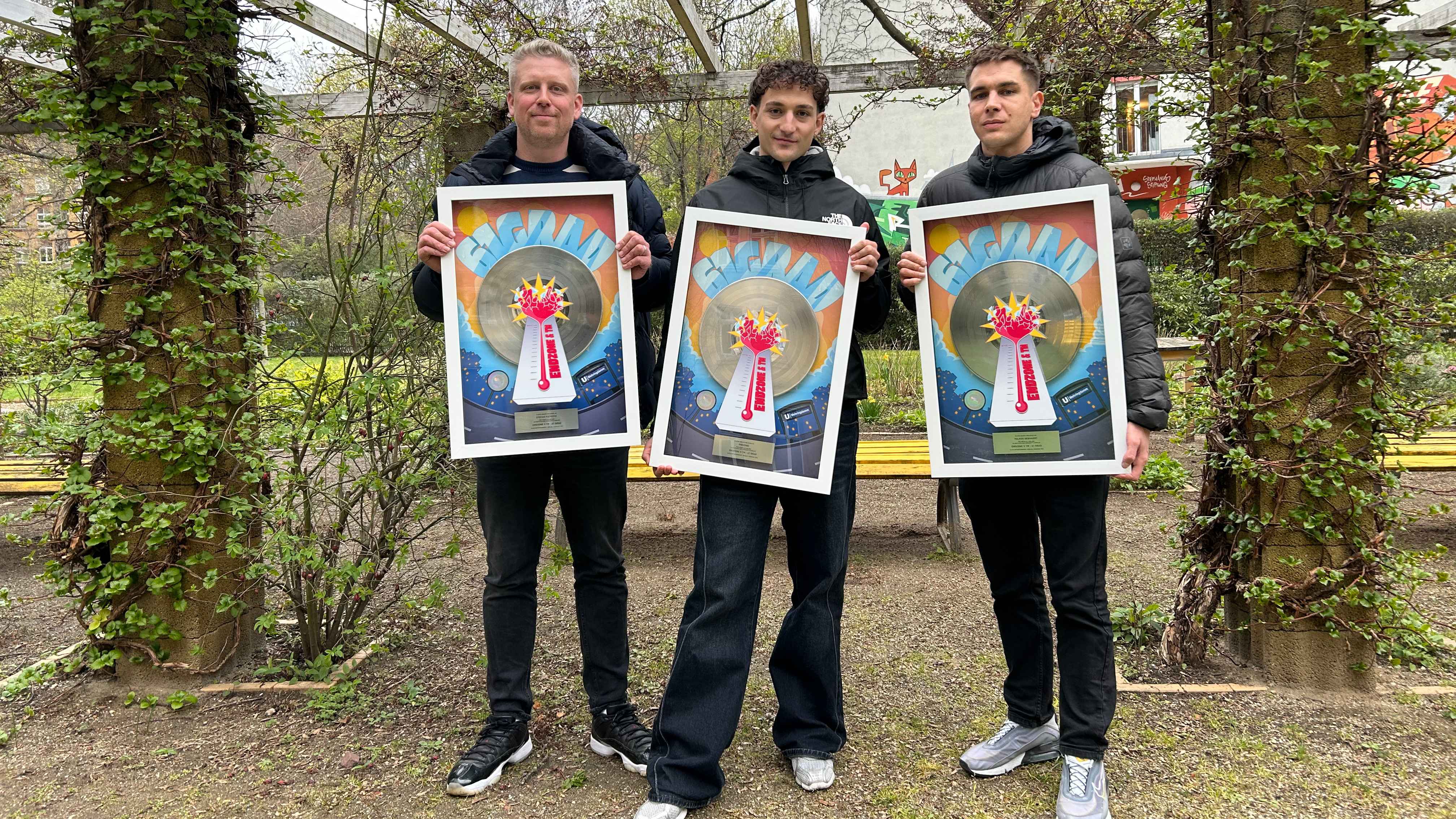 Präsentieren die Platin-Auszeichnung im Grünen (von links): Stefan Pieprzyk (Gründer und Geschäftsführer 2Live Entertainment), Endzone und Julian Behrens (Gründer und Geschäftsführer 2Live...