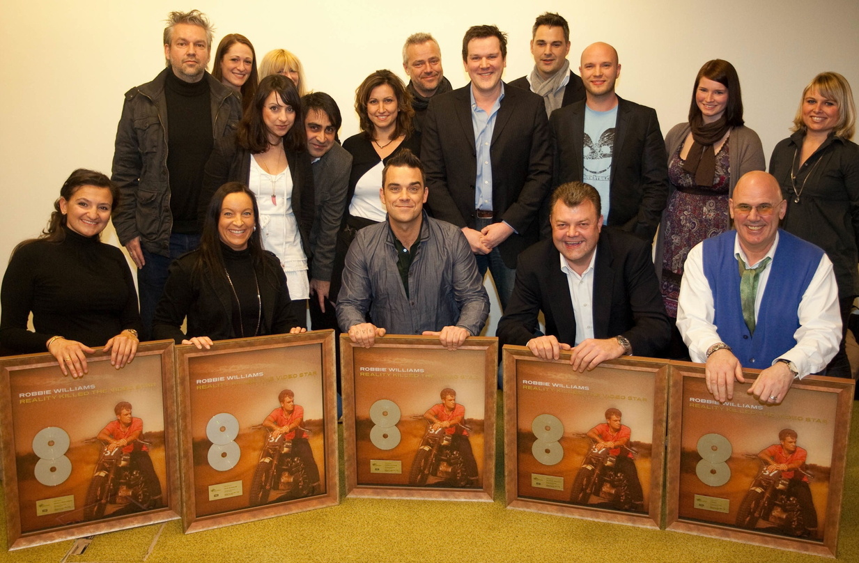 Bei der Verleihung: Robbie Williams (vorn, M.) mit dem EMI-Team sowie Vertretern von ProSieben und MM Merchandising Media||Bei der Verleihung mit dabei (hinten, v.l.n.r.): Giacomo La Tragn...
