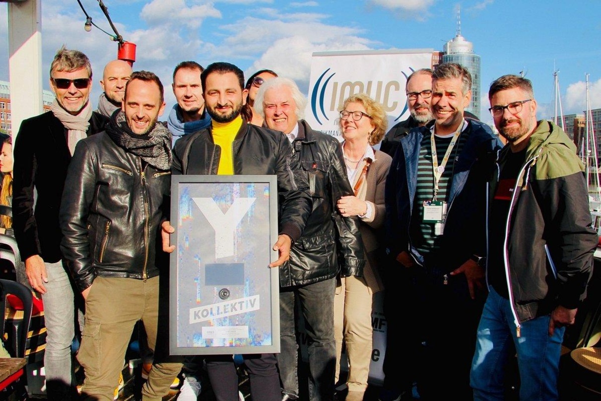 Bei der Medaillenvergabe auf dem Feuerschiff: Preisträger Ilhan Coskun (5. von links) und die Gratulanten von IMUC und MusikWoche