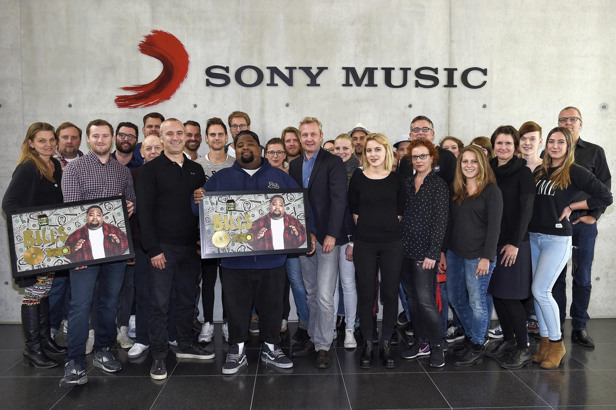 Mit Gold für inzwischen mehr als 200.000 verkaufte "Bills": LunchMoney Lewis (Mitte), umrahmt von Stefan Goebel (Senior Vice President Sony Music International GSA, links vom Künstler) und...