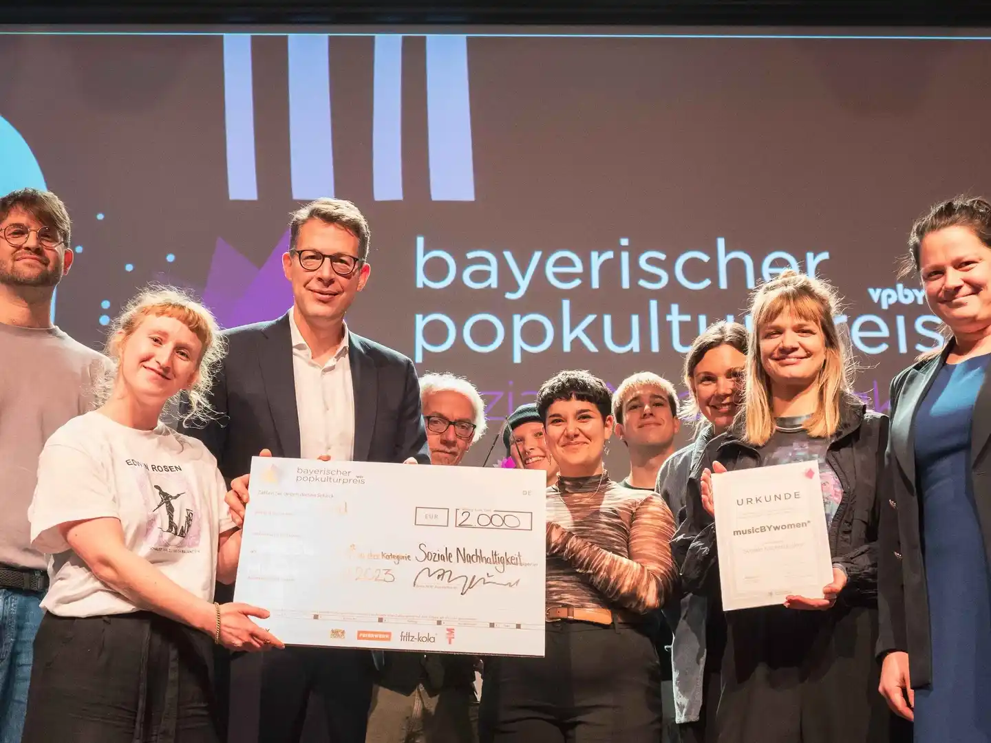 Bei der Verleihung des Bayerischen Popkulturpreis 2023 in München: die Preisträger:innen von musicBYwomen* mit Lukas Schätzl (VPBy, Erster von links), Kunstminister Markus Blume (Dritter v...
