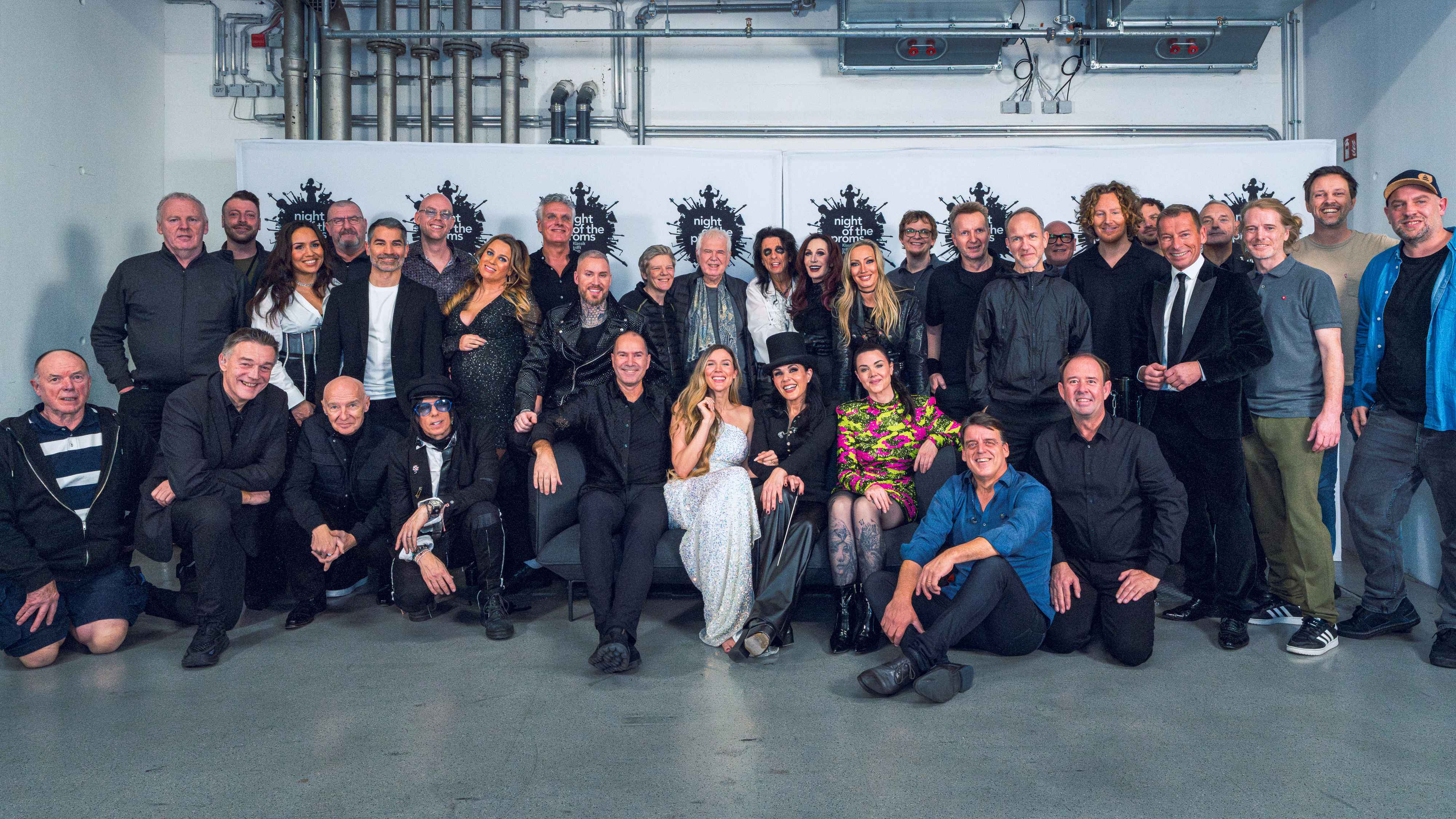 Entstand wieder in München: das Abschlussfoto der Night Of The Proms 2025 unter anderem mit Karen und Dirk Hohmeyer (hinten, 10. und 11. von links), Alice Cooper und Ehefrau Sheryl Cooper ...