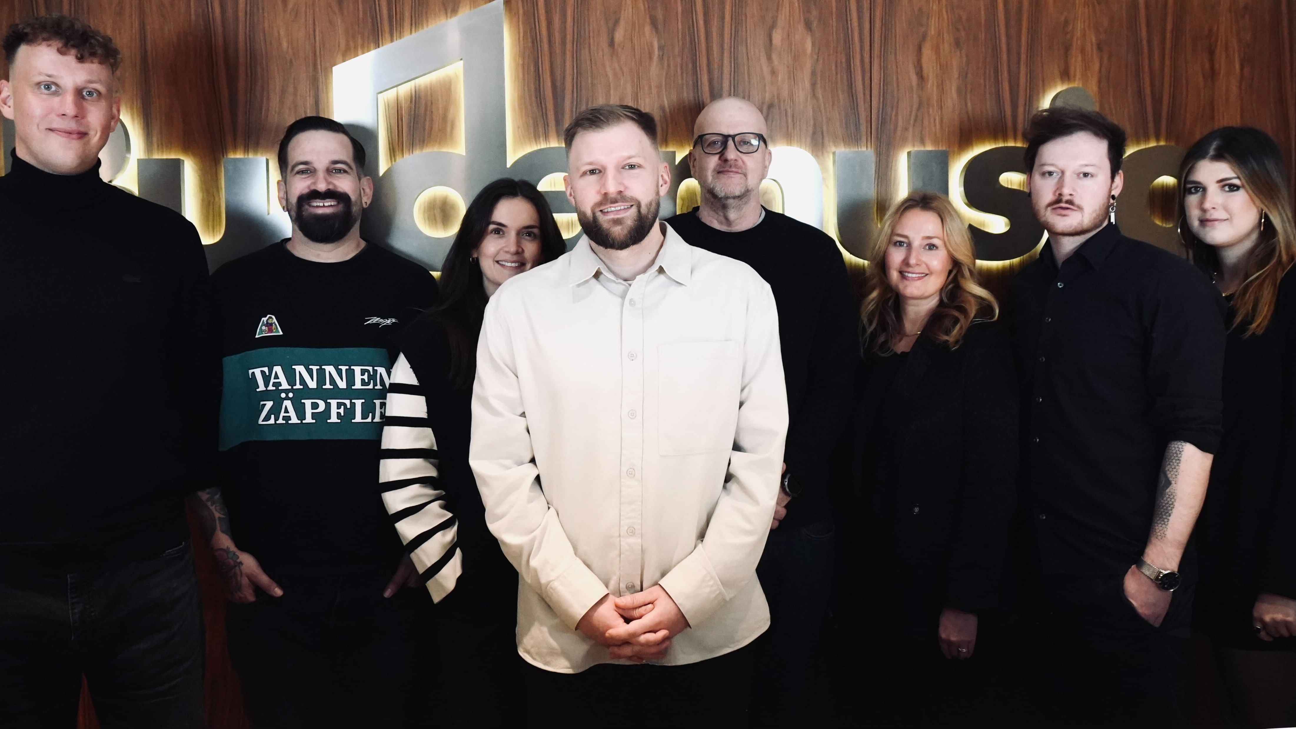 Posierten traditionell vor dem Budde-Logo (von links): Arne Milbrandt (Senior Artist- und Produktmanager 21 MGMT), Jan-Simon Wolff (Head of A&R), Mariel Barnjak (A&R Manager, beide Budde M...