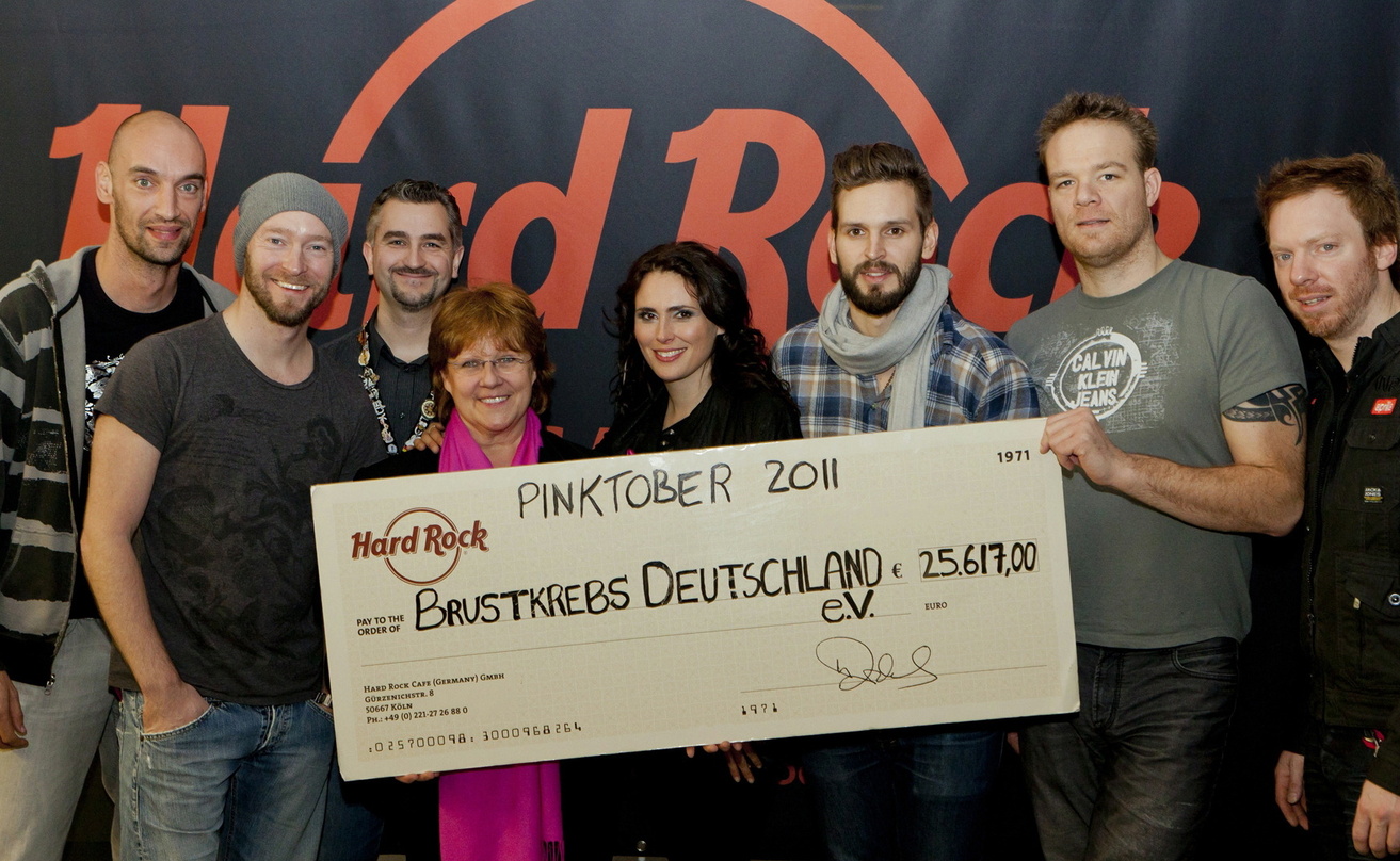 Erfolgreiche Spendensammler: Within Temptation und das Hard Rock Café||Zu Abschluss der Pinktober-Initiative trafen sich in Köln (v.l.n.r.): Jeroen van Veen, Ruud Jolie (beide Within Tempt...