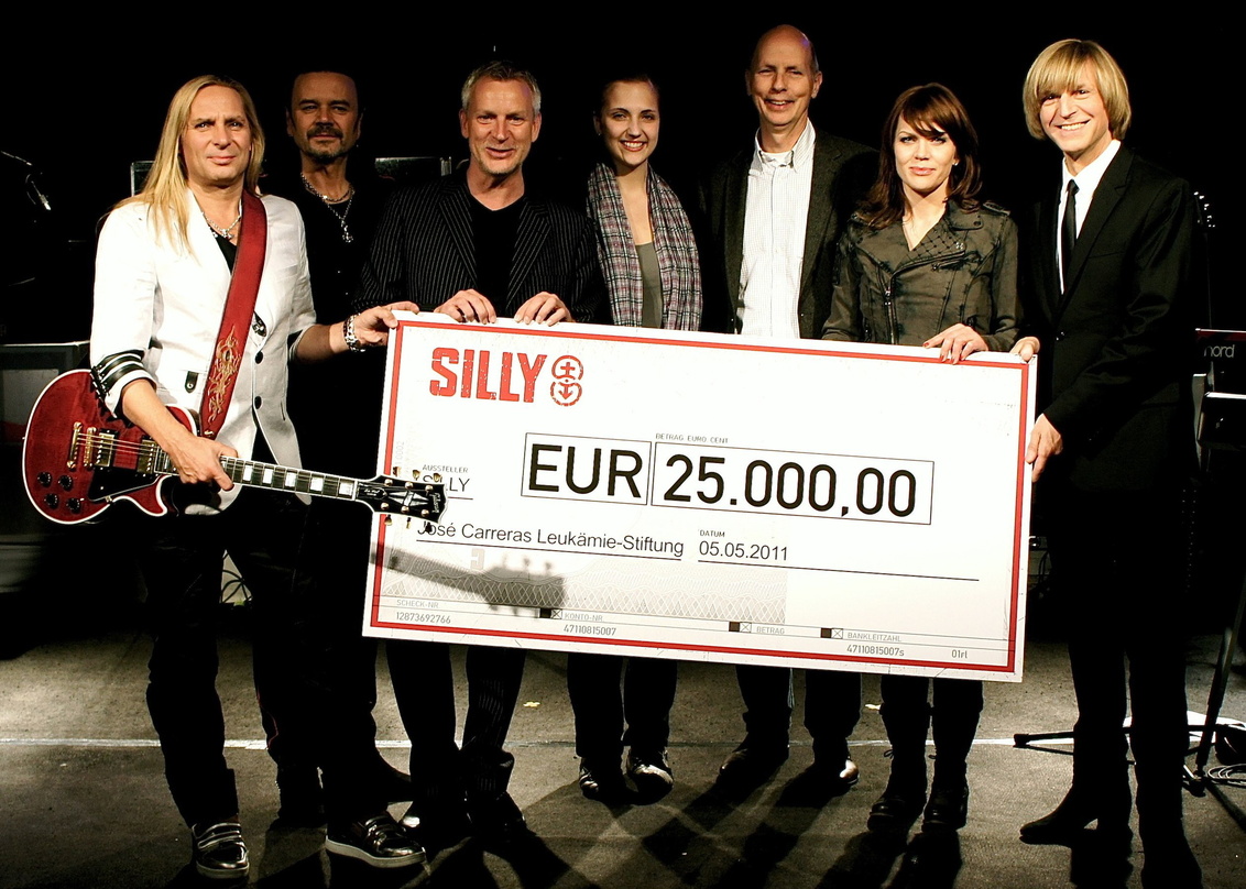 Bei der Scheckübergabe (v.l.n.r.): Uwe Hassbecker, Jäcki Reznicek (beide Silly), Dirk Michaelis (Sänger und Botschafter der José Carreras Leukämie-Stiftung), Ex-Patientin Jenny P., Prof. K...