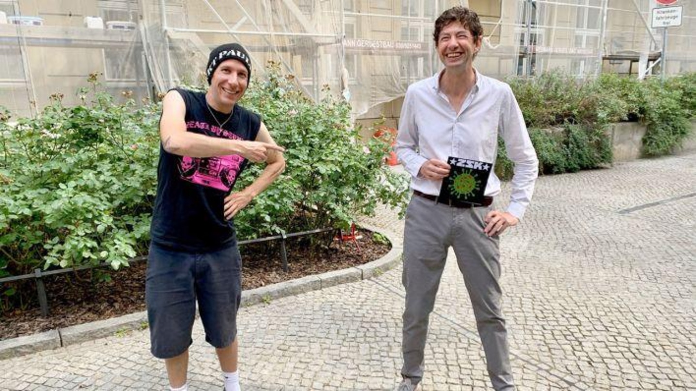 79eb87d61f9eb217f04eb013a6bb7d116c8eb776b0de76426d174841d997643b Bei der Übergabe: ZSK-Sänger Joshi und Christian Drosten