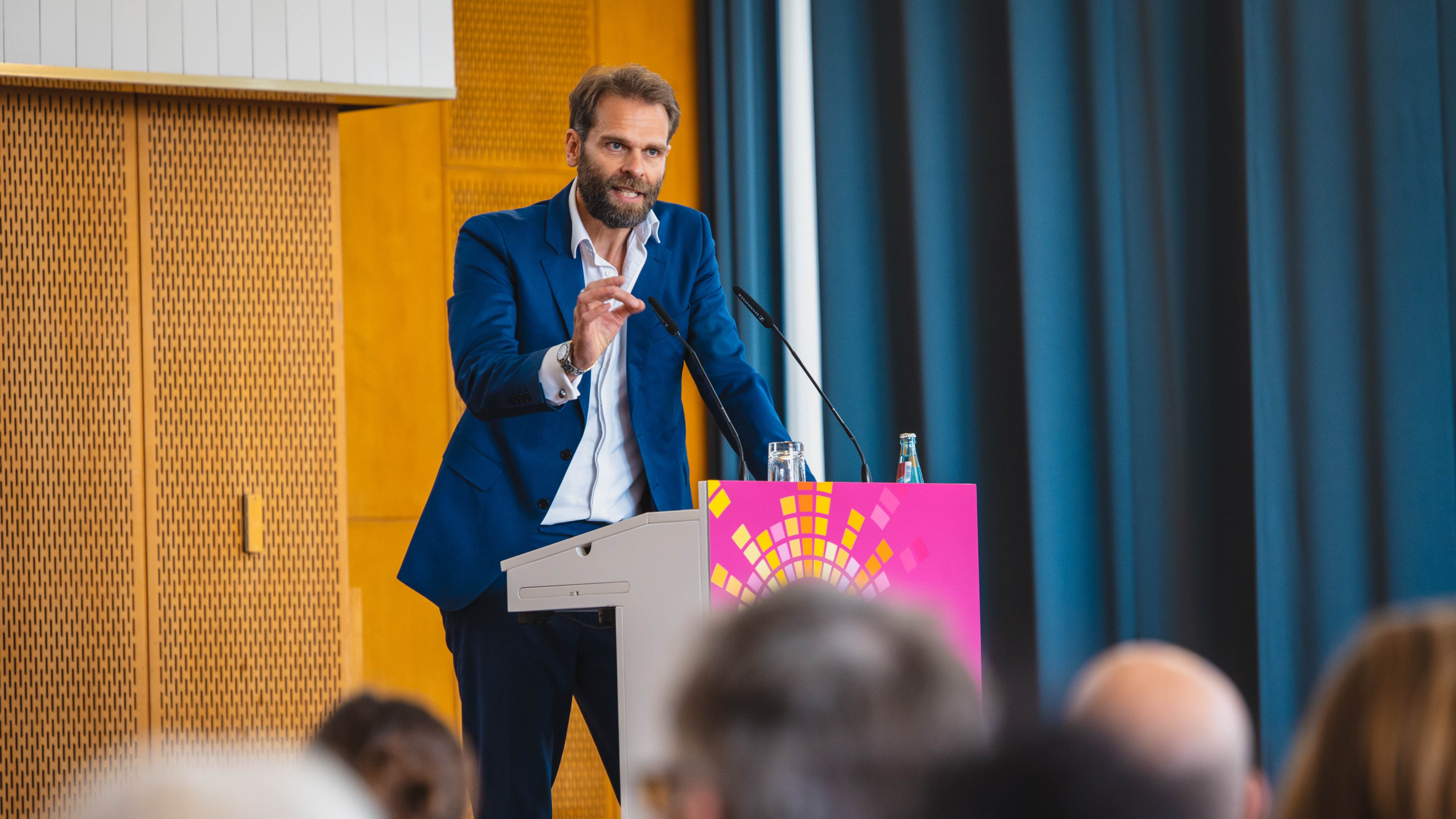 Sieht kreative Inhalte als „eine wesentliche Grundlage für die Entwicklung generativer KI-Systeme“: der Vorstandsvorsitzende Florian Drücke, hier im Sommer 2025 bei seiner Ansprache im Rah...