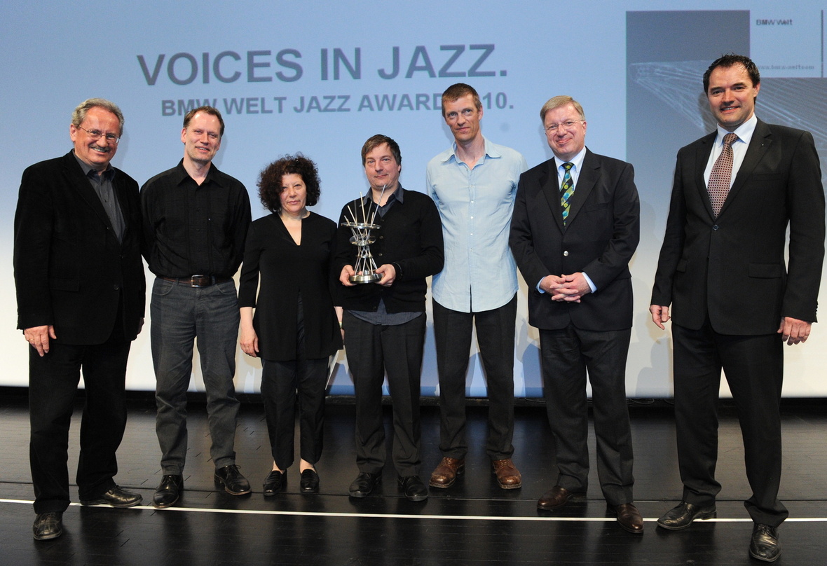 Zur Ehrung in der BMW Welt trafen sich (v.l.n.r.): Christian Ude, Sebastian Altekamp (Piano), Maria de Fatima (Gesang), Dré Pallemaerts (Percussion), Nicolas Thys (Bass), BMW-Vorstandsmitg...