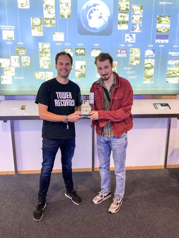 Der neue Longplay-Primus und sein Gratulant: Alligatoah (rechts) mit Mathais Giloth (GfK Entertainment) bei der Übergabe des Nummer 1 Awards