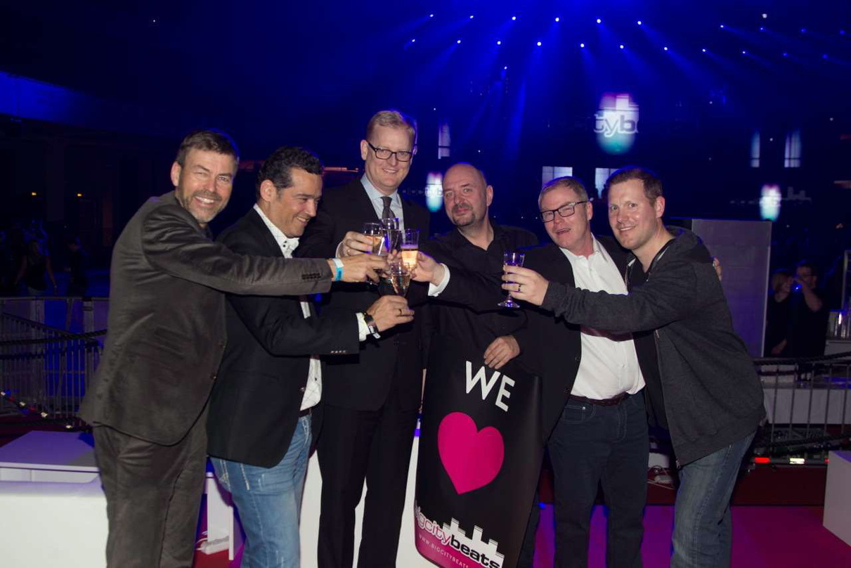Stießen gemeinsam auf den Geburtstag von BigCitybeats an (von links): Wolfgang Weyand (Geschäftsführer Weyand Entertainment Consulting), Oliver Schwebel (stellvertretender Geschäftsführer ...
