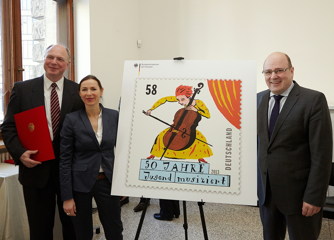 Bei der Übergabe der Sonderbriefmarke "50 Jahre Jugend Musiziert" (von links): Prof. Martin Maria Krüger (Musikrat), Briefmarken-Designerin Kitty Kahane und der Parlamentarische Staatssekr...