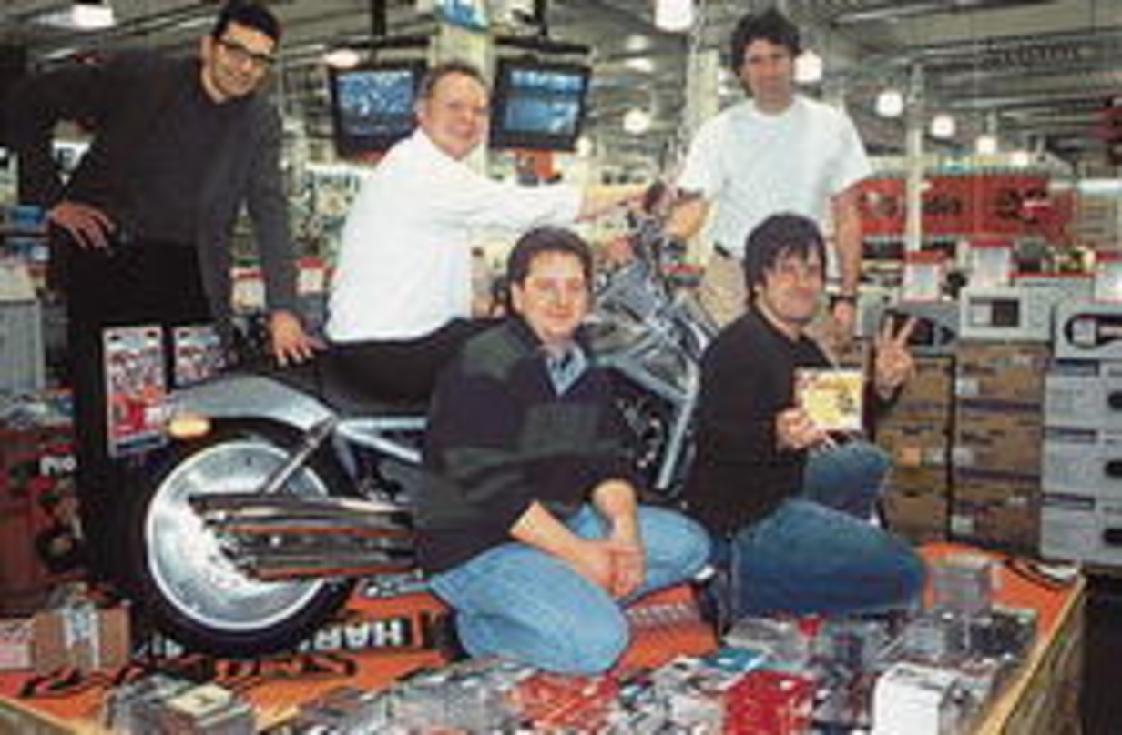 Mit der Harley da (hinten, v.l.n.r.): Jürgen Ziegler (Geschäftsführer Harley-Davidson Fiereks), Guido Schlender und Konrad Reiter (Abteilungsleiter Tonträger MediaMarkt Solln) sowie (vorn)...