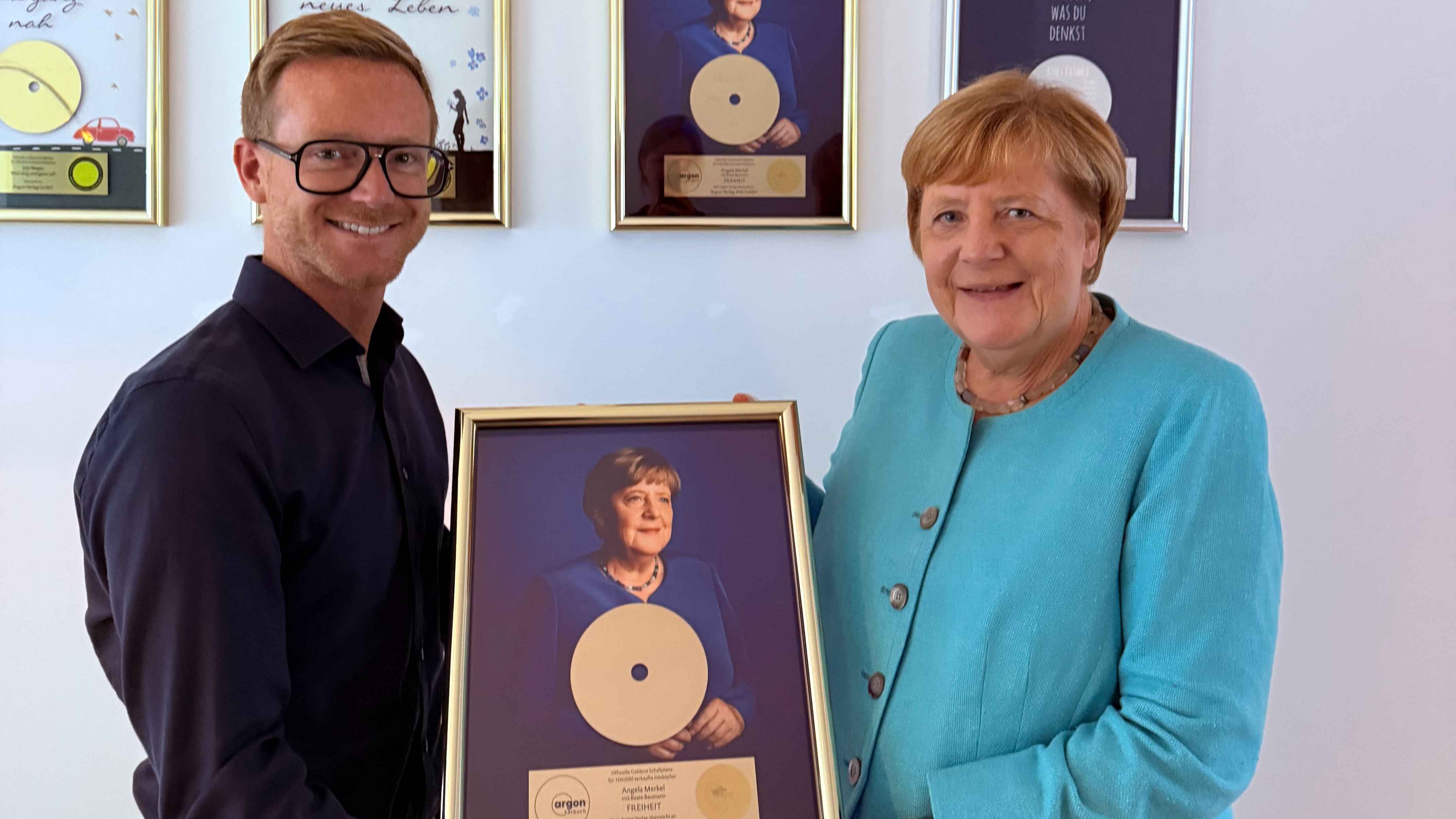 bda35b16 b456 4fac bd81 6e84c994c776 Mit der Gold-Auszeichnung: Frederik Wehmeier (Geschäaftsführer Argon Verlag) mit Angela Merkel.
