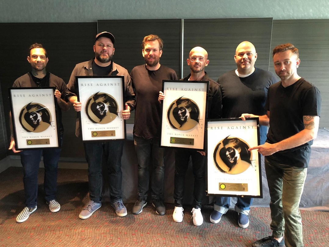 Feierten bei Rock am Ring mit Gold (von links): Joe Principe, Brandon Barnes (beide Rise Against), Jens Winkelmann (Head Of Marketing Rock), Zach Blair (Rise Against), Ulf Zick (Managing D...