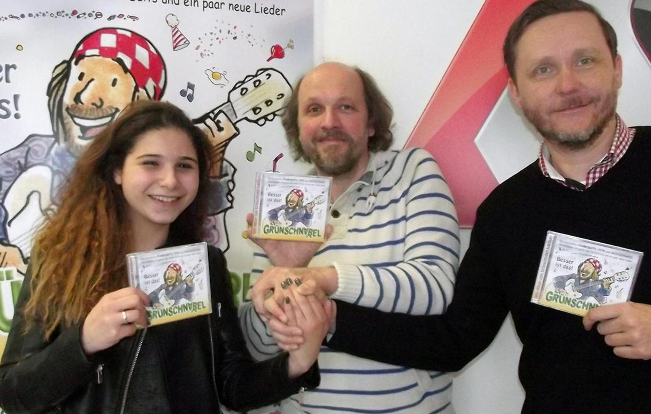 cf51b5aa26c6cb3ca09b836e0ee9629a79e1069cf523fc00239822449628c397 Präsentieren das neue Album von Grünschnabel: Anjuli Bidou (Produktmanagerin Membran Media GmbH), Burghardt Wegner alias Grünschnabel und Joachim Krohn (Vertriebsleiter Membran Entertainme...