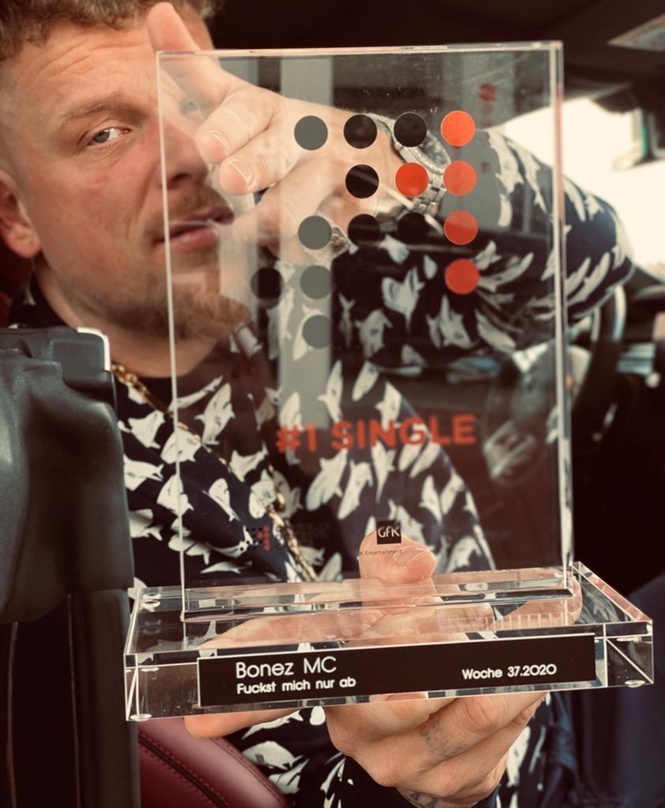 Hält sich seinen neuen Nummer 1 Award im Singles-Segment vors Gesicht; Bonez MC