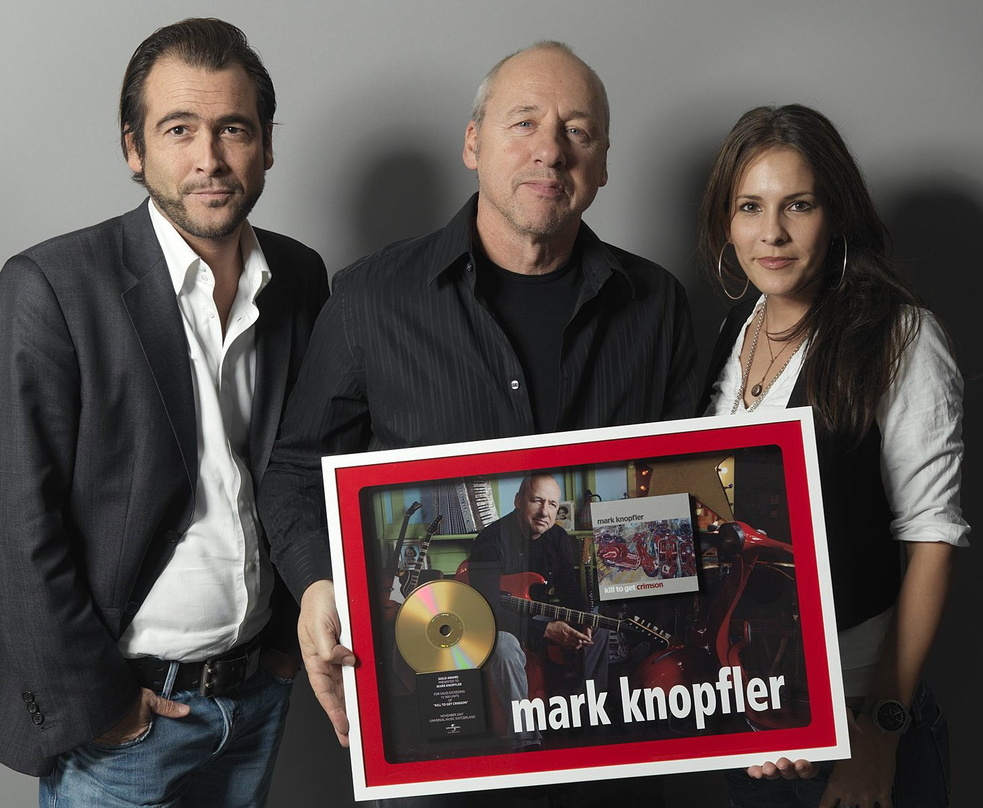 Von Universal vergoldet: Mark Knopfler (M.)||Bei der Verleihung mit dabei (v.l.n.r.): {mlbipers.15632.Ivo M. Sacchi|U|T|7146} (Managing Director Universal Music Schweiz), Mark Knopfler und...
