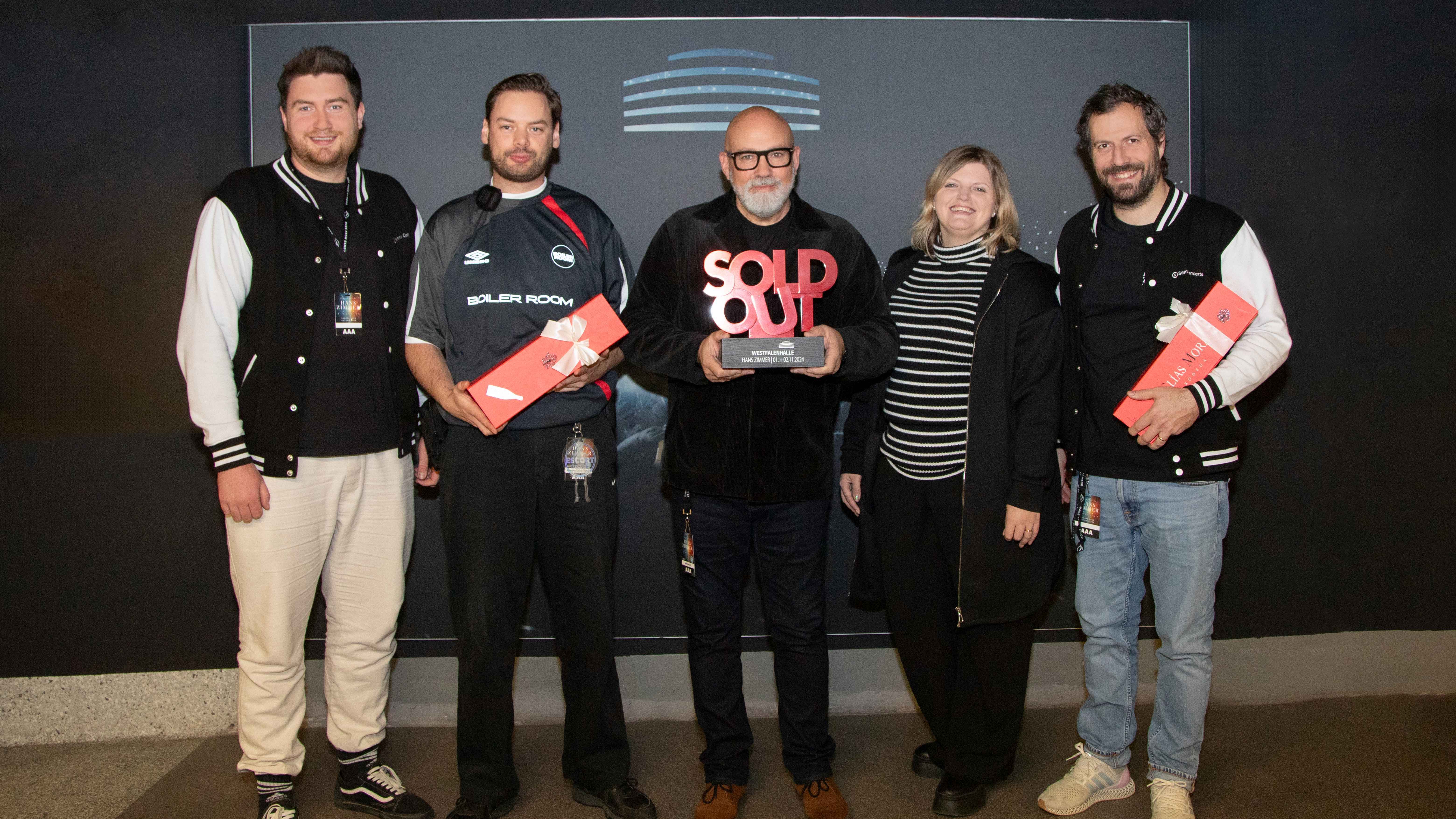 f131cce3 c4e9 4366 b3b2 b04085aac2c0 Mit dem Award und zwei Flaschen Rotwein (von links): Philipp Rothenmeyer, Johannes Stephan (beide Semmel Concerts), Matt Dunkley (Dirigent), Jill Richter (Projektleiterin Westfalenhallen U...