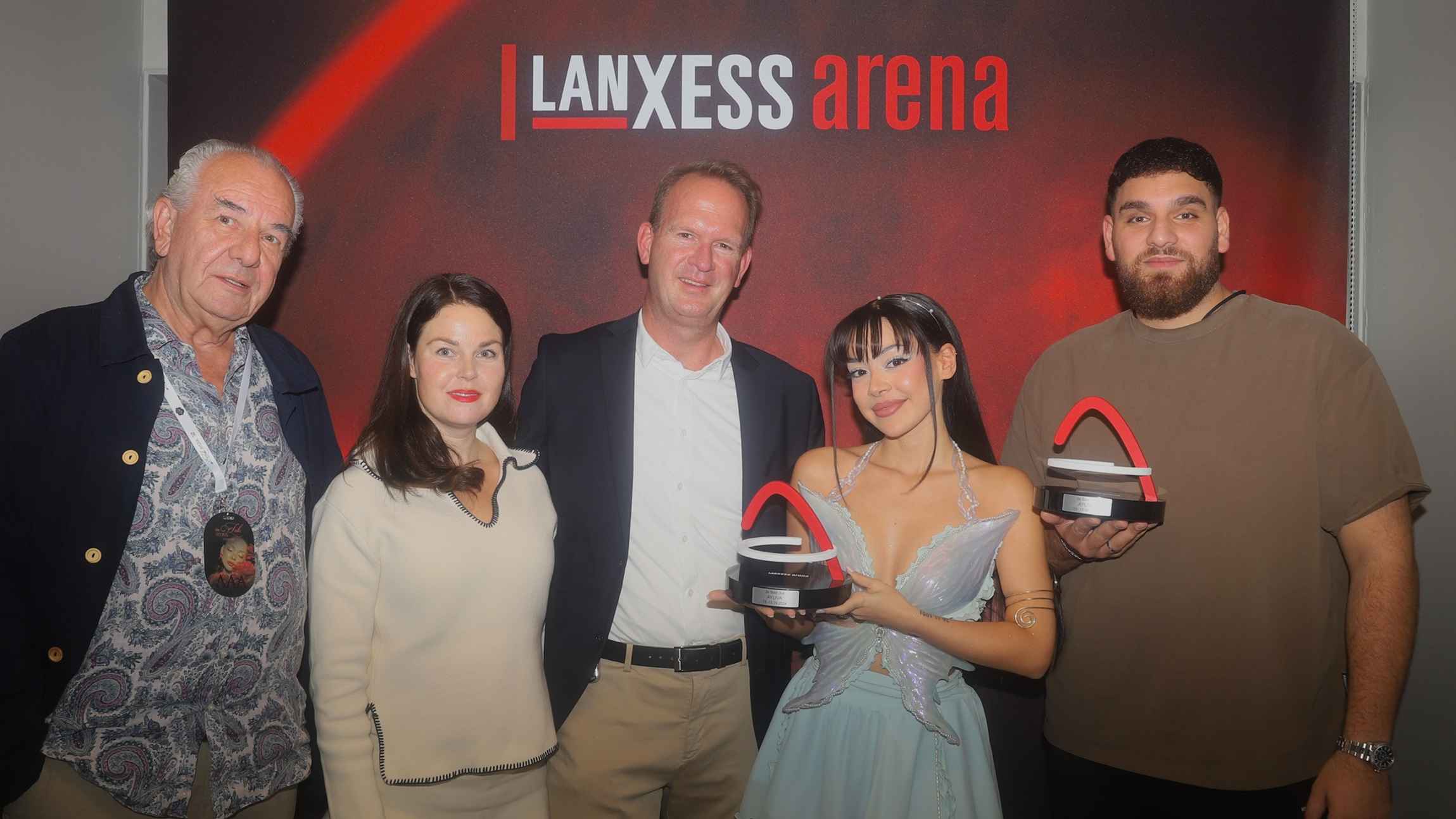 Mit der Trophäe (von links): n.n. (Management), Eileen Brunngräber (Phoenix Production), Stefan Löcher (Geschäftsführer Lanxess Arena), Ayliva sowie Bilal Omeirat (Management).