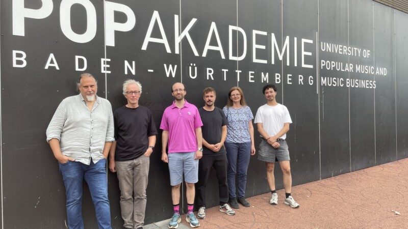 Nehmen unter dem Motto „Perspektive 2036 – Musikwirtschaft in der Zukunft“ gemeinsam unter die Lupe, wie generative Künstliche Intelligenz die Bereiche Musikproduktion, Distribution, Rechteklärung, Lizenzierung und Verwertung verändern kann (von links): Prof. Dr. Alexander Endreß (Studiengangsleitung Musikbusiness B.A. Popakademie), Stefan Holly (Business Development, Geschäftsfeldleiter Defense and Security, Fraunhofer IDMT), Dr. Andrew McLeod, David Stammer (Projektmanagement Digital Innovation Popakademie), Hanna Lukashevich (Gruppenleiterin Semantic Media Technologies, Fraunhofer IDMT) und Noah Choi (Wissenschaftlicher Mitarbeiter Popakademie. Foto: Popakademie Baden-Württemberg