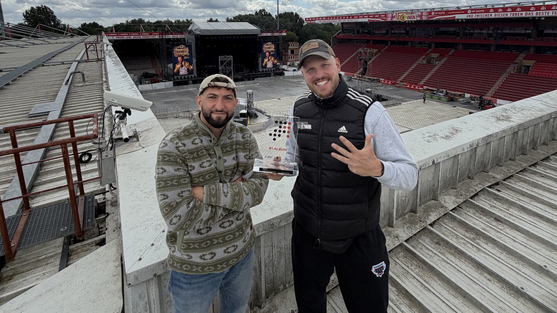Team Finch der Rapper mit Manager Cihan Bilgin _C_ Management Finch Mit der Nummer-eins-Trophäe: Rapper Finch (rechts) steigt mit Manager Cihan Bilgin aufs Dach des Berliner Stadions An der Alten Försterei. Foto: Management Finch