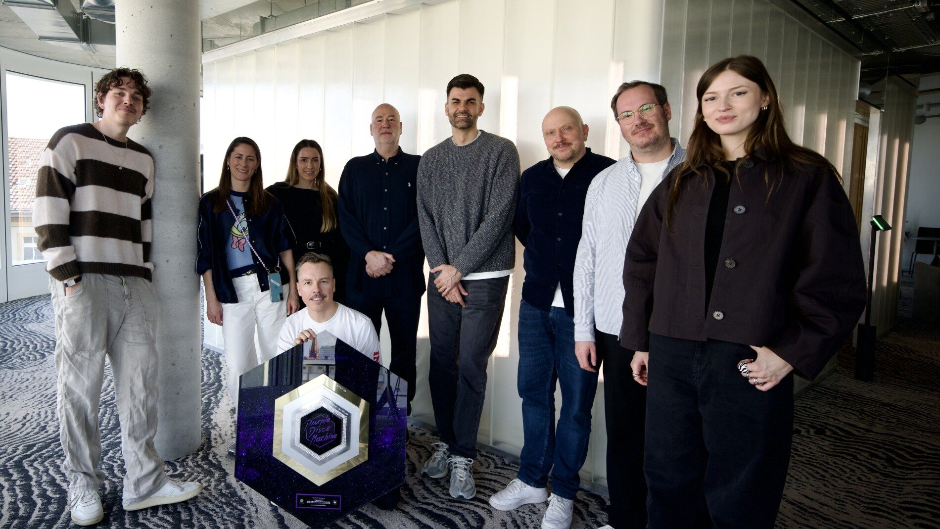 Bei der Auszeichnung (von links): Max Holtey (Columbia Creative Marketing Manger), Teresa Pighin (Product Management), Lilly Rumler (Management), Tino Piontek, Matt Jagger (Management), Kristian Lesic (Director Marketing Columbia), Bastian Ständer (VP Marketing Columbia Label Group), Nathan Hunt (Head of International Marketing) und Emily Grace Lardon (A&R Manager).